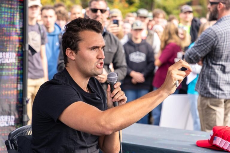 Charlie Kirk speaking at podium, linked to reports of his consideration of becoming Catholic