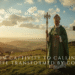 Saint Patrick standing on a sunlit Irish hillside holding a staff and shamrock, with a Celtic cross in the background
